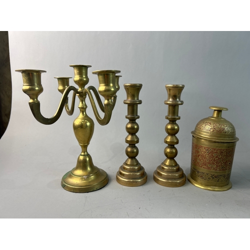 317 - A collection of pewter jugs and brass candle holders and a tea caddy.