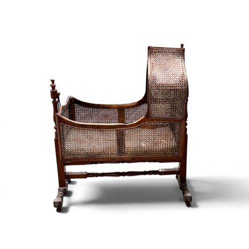 18 - A William IV Mahogany and cane Rocking cradle.Gothic shaped top with round finials.107 x 45 x 125cm... 