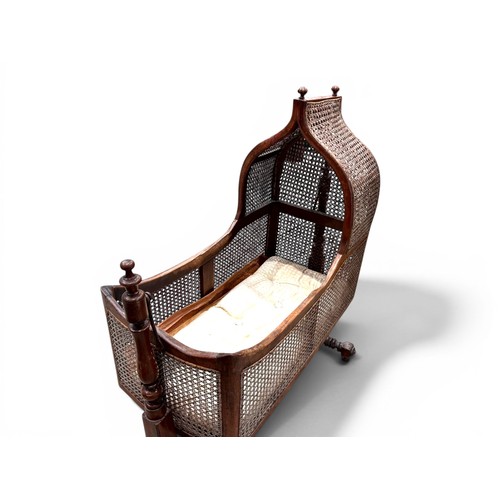 18 - A William IV Mahogany and cane Rocking cradle.Gothic shaped top with round finials.107 x 45 x 125cm... 
