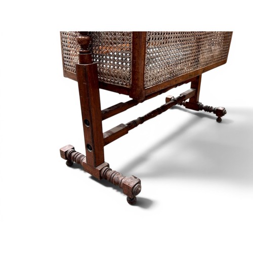 18 - A William IV Mahogany and cane Rocking cradle.Gothic shaped top with round finials.107 x 45 x 125cm... 