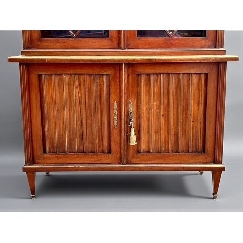 5 - A French Empire Walnut bookcase.Astragal glazed doors above two door cupboard. Ormolu mounted decals... 