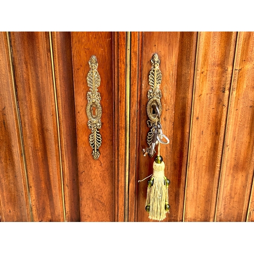 5 - A French Empire Walnut bookcase.Astragal glazed doors above two door cupboard. Ormolu mounted decals... 