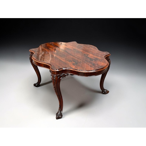 7 - A George III Rosewood centre / dining table.Early 19th century.Serpentine top, with carved legs and ... 
