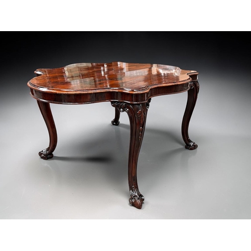 7 - A George III Rosewood centre / dining table.Early 19th century.Serpentine top, with carved legs and ... 
