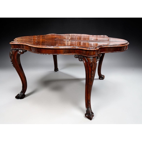 7 - A George III Rosewood centre / dining table.Early 19th century.Serpentine top, with carved legs and ... 