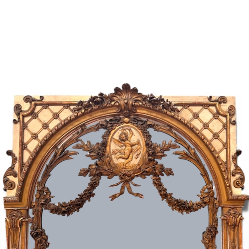 13 - A very large French Louis XVI Giltwood Trumeau mirror.Late 18th century.Central carved Putto motif a... 