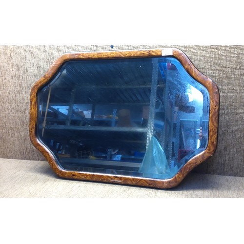 283 - An unusual shaped Bevel edged mirror with walnut surround . 80cm x 53cm.