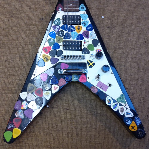 23 - Electric vision flying V guitar with approximately 92 plectrums attached