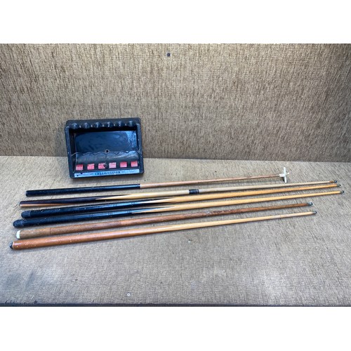 12 - Selection of pool cues with a pool cue stand.