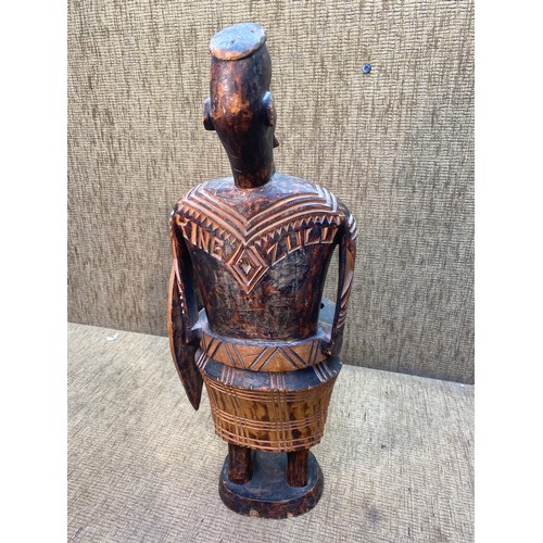 705 - A carved Tribal figure standing 60cm tall.