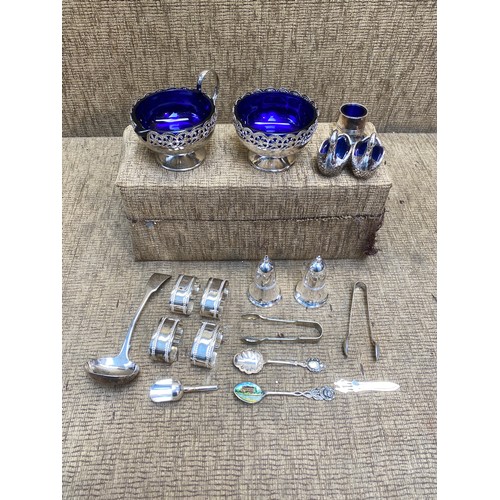 1135 - A collection of silver-plated condiments with royal blue glass liners, napkin rings, sugar tongs and... 