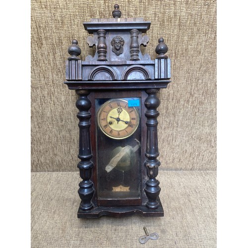 1171 - Antique wall clock with its key.