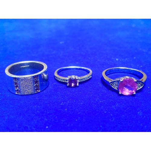 855 - Three silver rings all stamped 925 all with clear and purple stones.