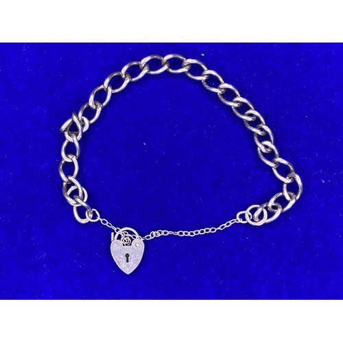 856 - Silver charm bracelet with a heart locket stamped Sterling silver.