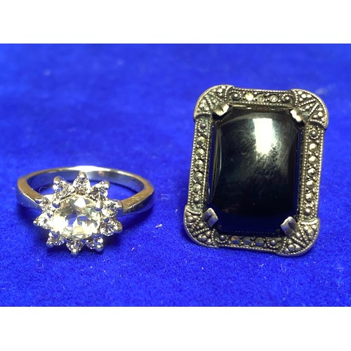 857 - Two silver rings one with a black onyx stone, one with cluster of clear stones stamped 925 and sterl... 