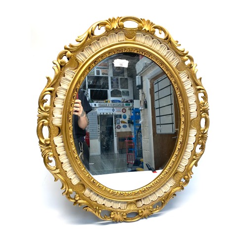 16 - Oval-shaped gold gilted mirror 69cm x 58cm.