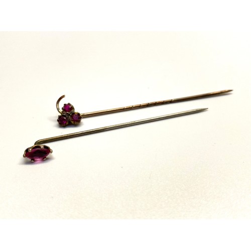 966 - Pink sapphire stick pin and a yellow metal pin with garnets.