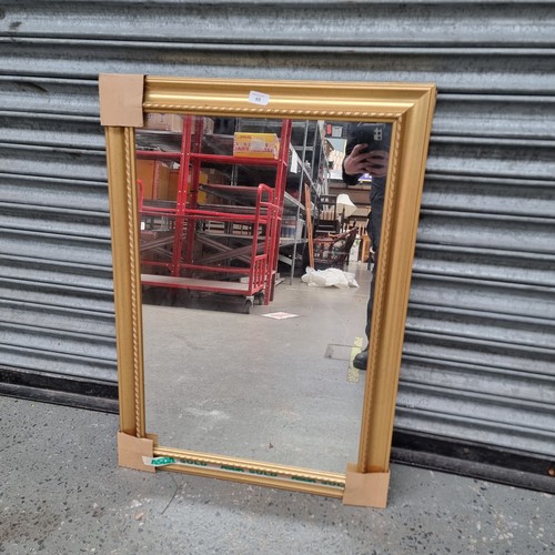 49 - Gold framed wall hanging mirror 90cm x 63cm.