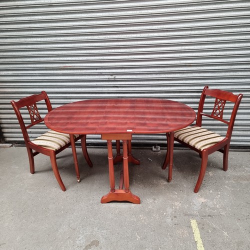 1051D - Flamed mahogany drop leaf table and two dining chairs.