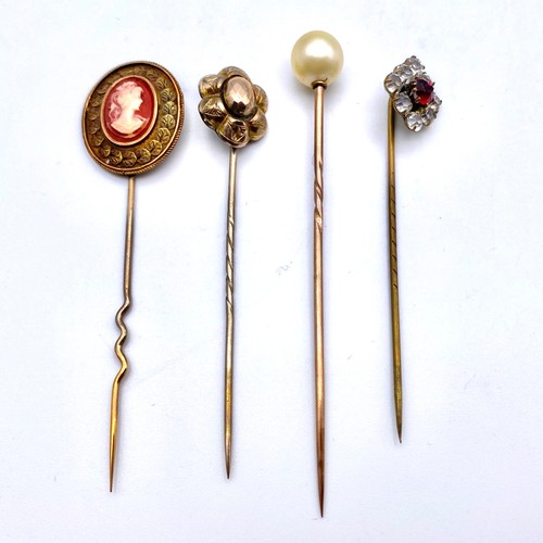 933 - Four tie/cravat pins with yellow metal tested as gold. Moonstone and red abalone stones. In presenta... 