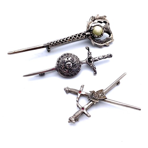 940 - Three Silver brooches shield and sword and thistle, and a interesting brooch with a skull and crossb... 