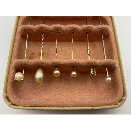 944 - Six delicate pearl tie pins including a horseshoe, some gold in a collectors box. (NHMYOMU).