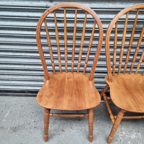 1452 - Four wheel backed country pine dining chairs.