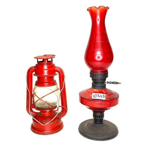 1053D - Red metal hurricane lamp and a metal and red glass paraffin lamp.