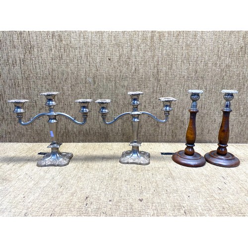 527 - Two Silver-plated candelabras and a pair of silver-plated and treen candlesticks.