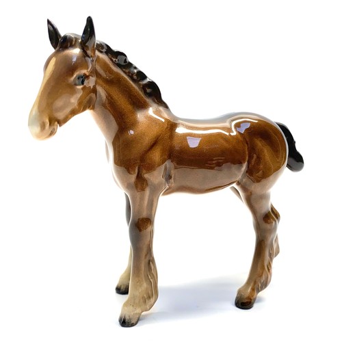 679 - Two Beswick brown ceramic horses ( 13cm tall and  24cm long). Largest has damage to ear .