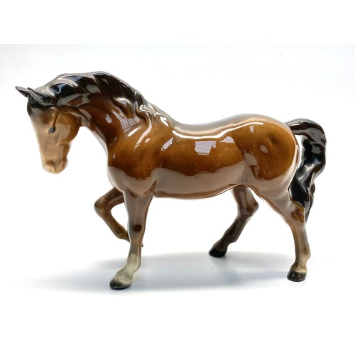 679 - Two Beswick brown ceramic horses ( 13cm tall and  24cm long). Largest has damage to ear .