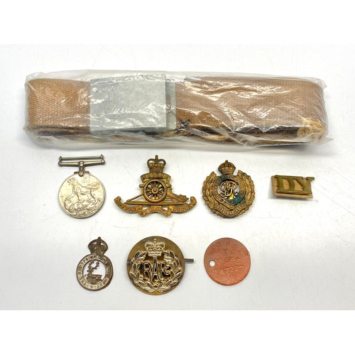 690 - 6 military cap badges, a military belt and a British WW2 war medal and an ID disk for JPT Bryant.