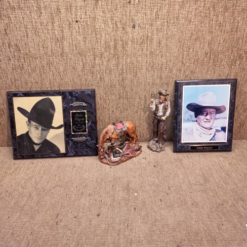 6 - Two cowboy statues and a pair of John Wayne plaques.