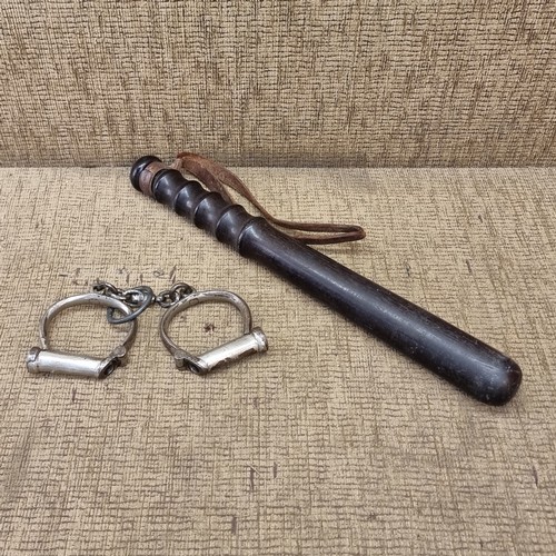 704 - Vintage Hait police hand cuffs and a late Victorian truncheon.