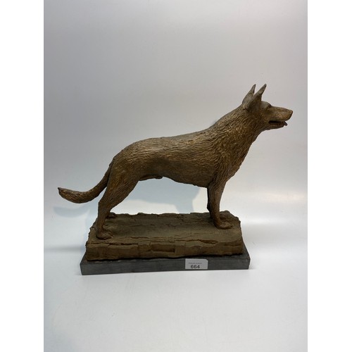 664 - Large handmade bronze coloured dog statue on a slate base 30cm x 32cm.