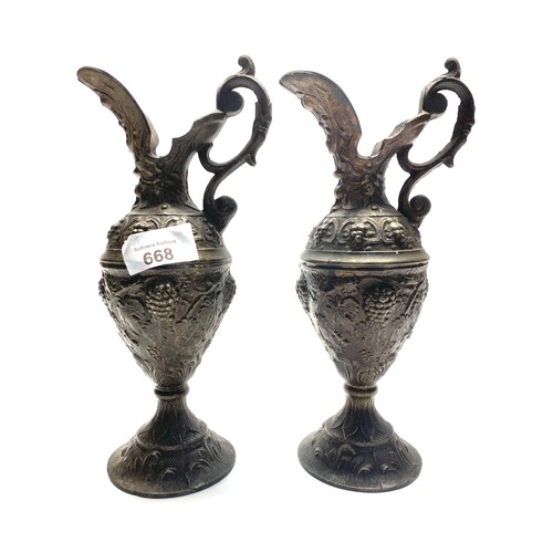 668 - Two Arts and crafts cast metal vases 27cm tall.