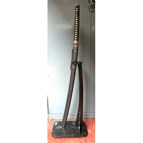 1167 - Detailed decorative samurai sword on a stand.