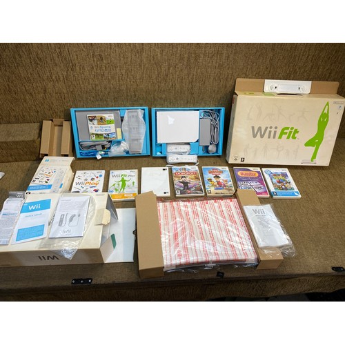 1148 - Wii console with additional controller, Wii fit pad and a selection of games including Wii sports.