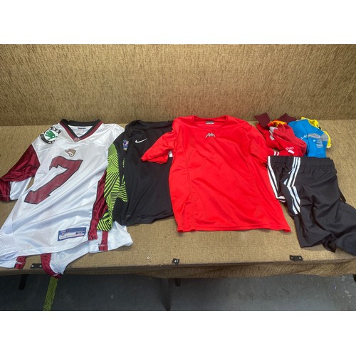 509 - Selection of sportwear including: NFL jerseys, Manchester united T-shirt and Welsh Cappa T-shirt.