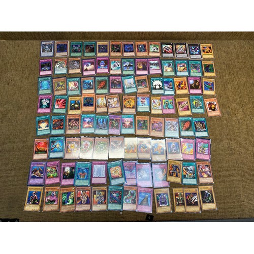 733 - Approximately 100 yu-gi-ho trading cards including an range of different rarity of cards.