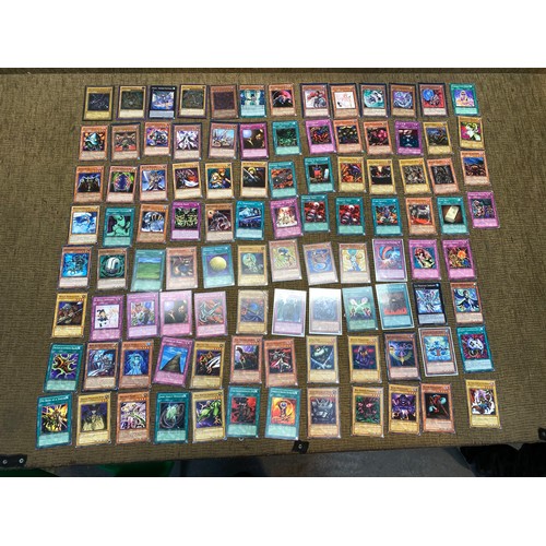 735 - Approximately 100 yu-gi-ho trading cards including an range of different rarity of cards.