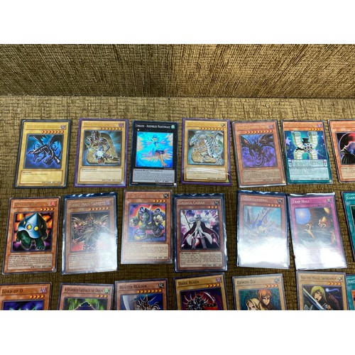 735 - Approximately 100 yu-gi-ho trading cards including an range of different rarity of cards.