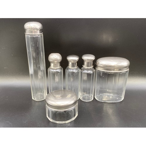 555 - Collection of six cut crystal and silver plate dressing table bottles.