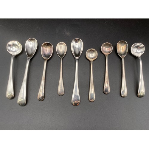 556 - Nine silver salt spoons.