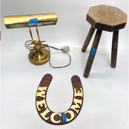 1044 - 3 vintage items including: a milking stool, cast iron horseshoe welcome sign and a clean brass banke... 