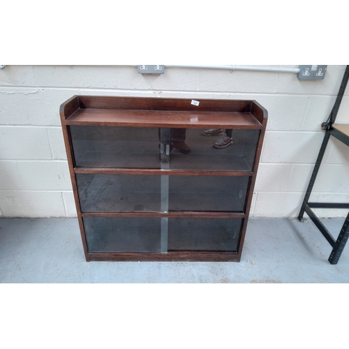 131 - A vintage solid oak bookcase with sliding glass doors