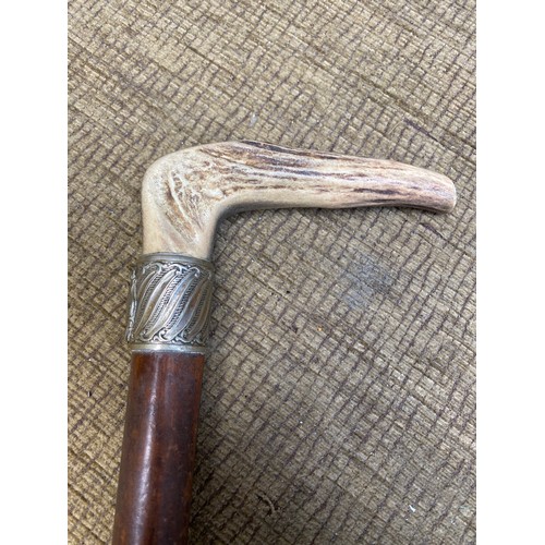 678 - Vintage walking cane with deer antler handle and white metal band.