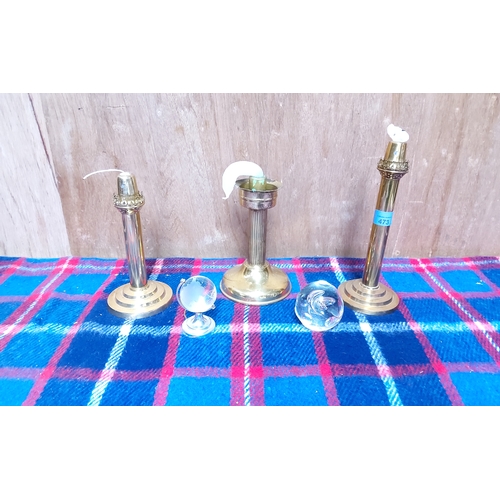 473 - Brass candlesticks, a paperweight and a glass globe on stand