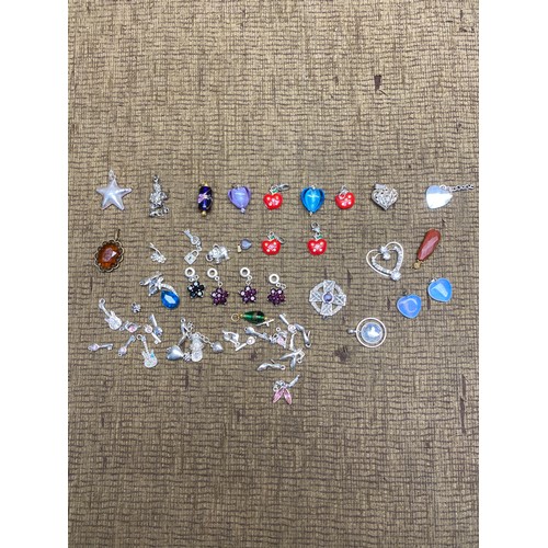 491 - Collection of over 50 pendants and bracelet charms including some silver.