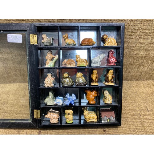 Collection of wade whimsies in a mirrored glass display case